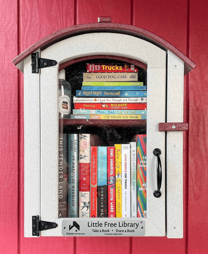 Composite Two Story Arched Little Free Library on a red wall with books